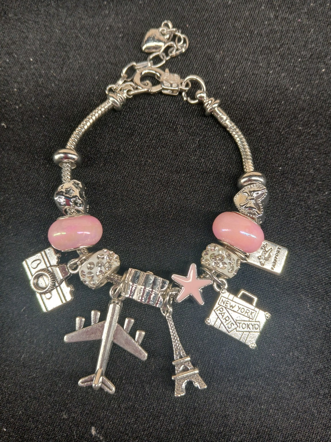 Pink Jetsetter Travel Charm Bracelet close-up with airplane and Eiffel Tower charms