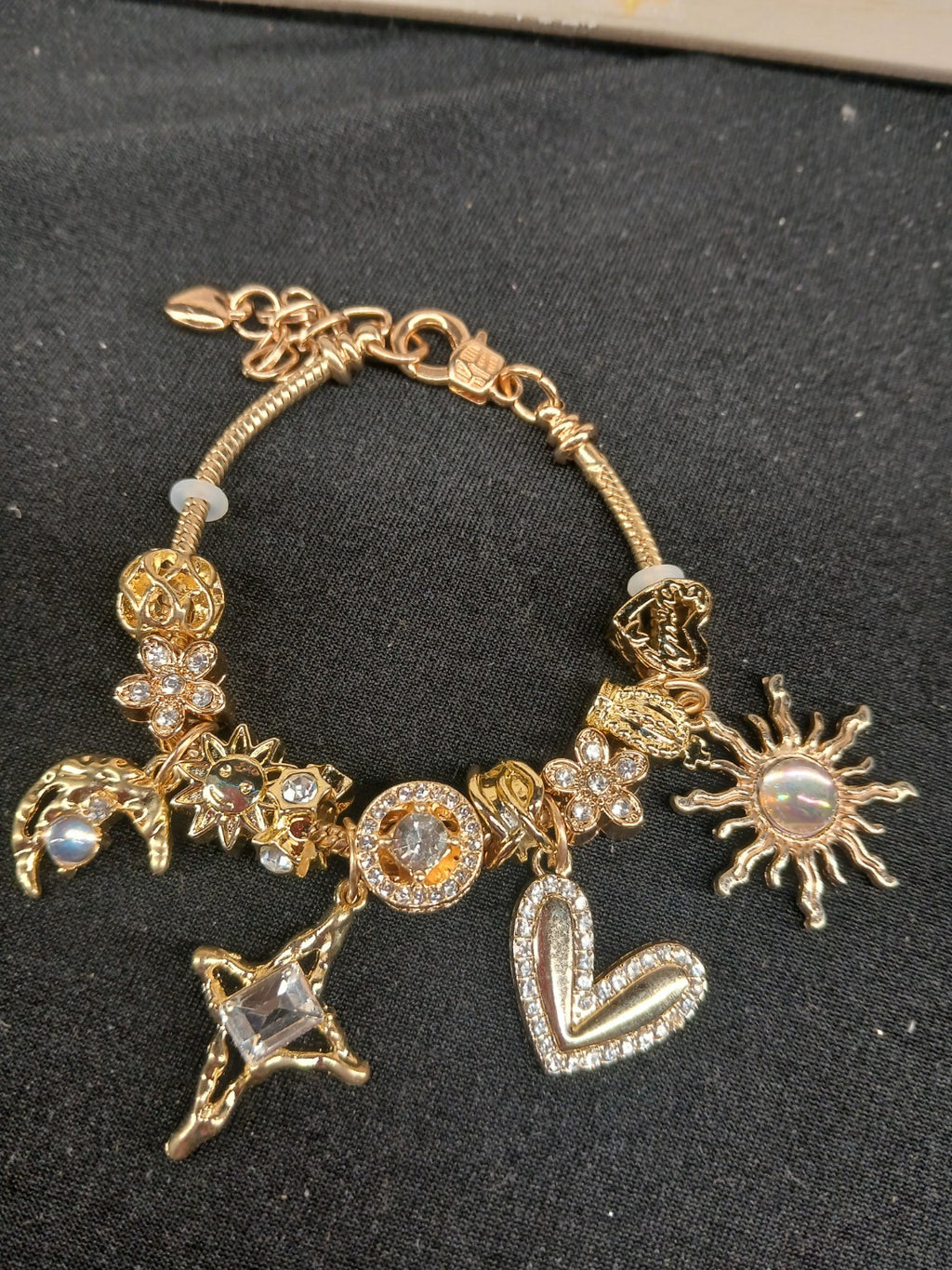 Golden Celestial Love Charm Bracelet close-up with sun, moon, star and heart charms