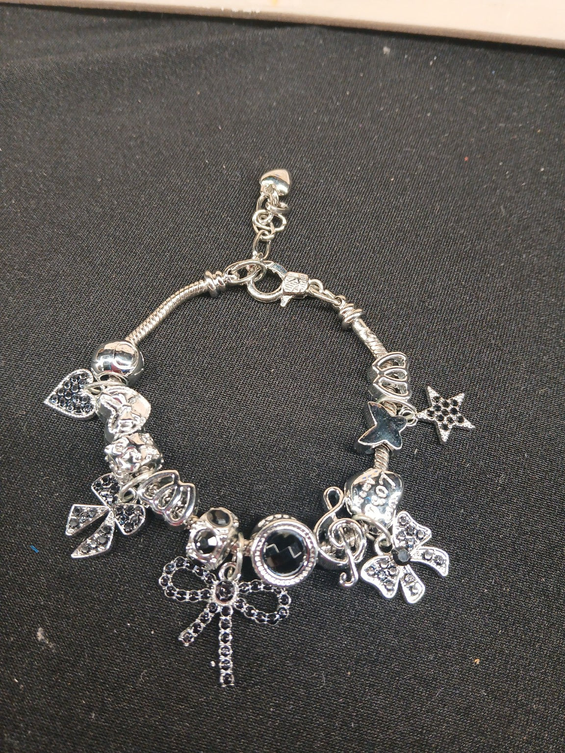 Midnight Bow Sparkle Charm Bracelet close-up with black bows and silver-tone charms