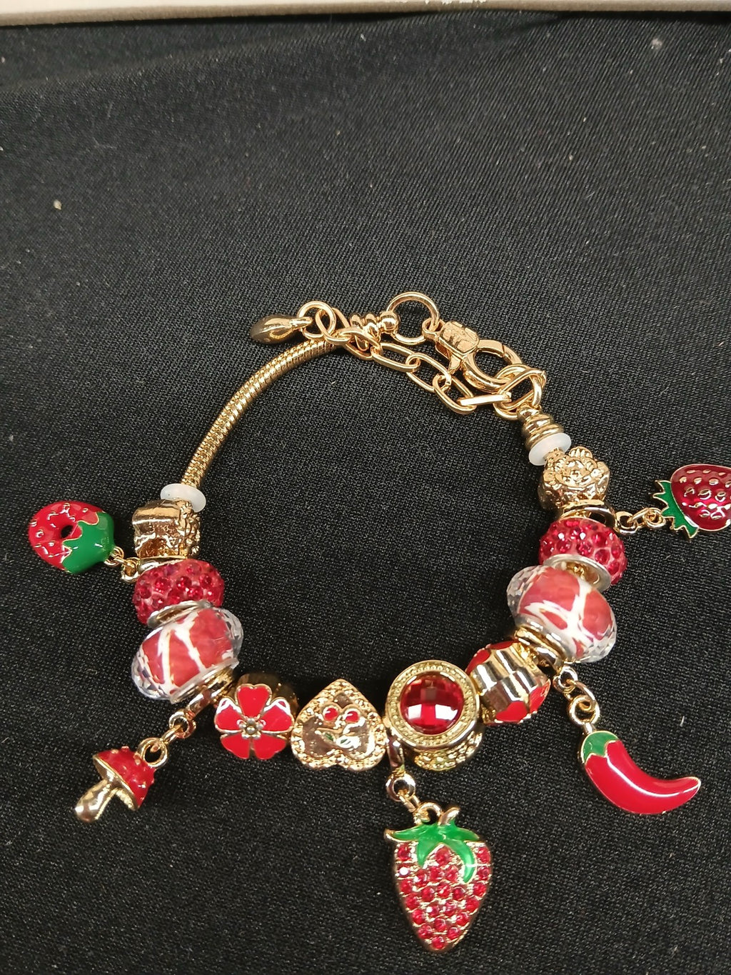 Close-up red and gold strawberry spice charm bracelet