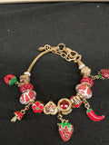 Close-up red and gold strawberry spice charm bracelet