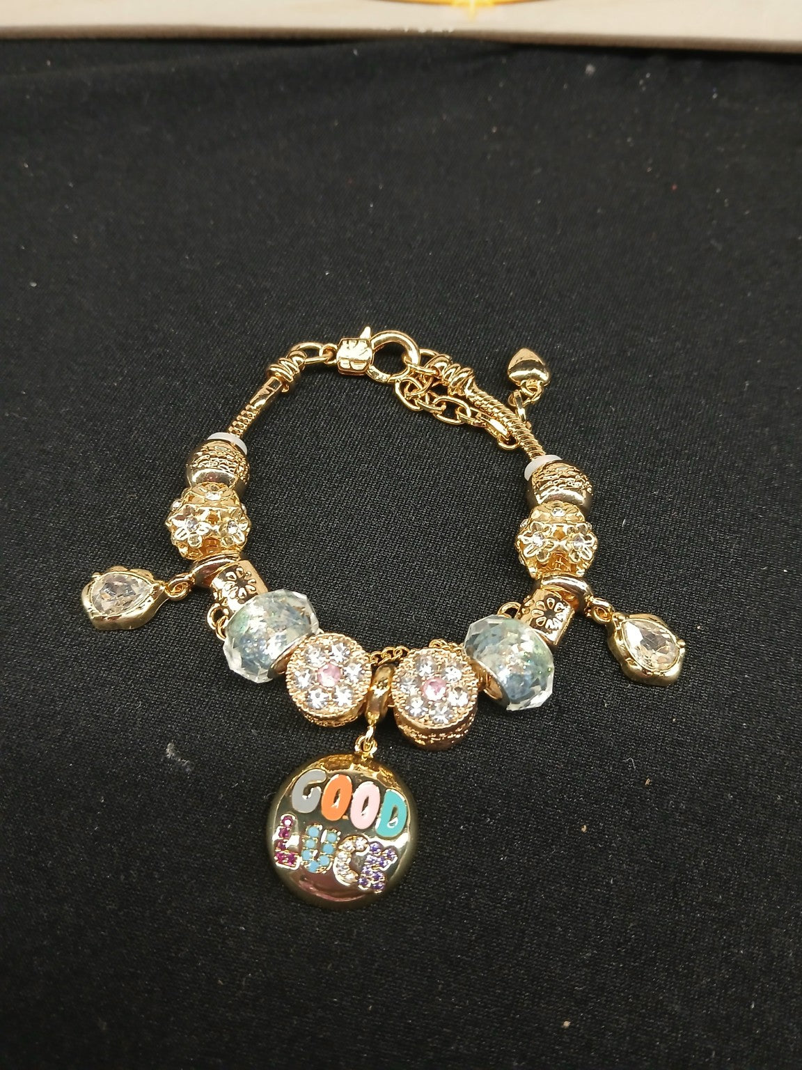 Good Vibes gold-tone charm bracelet closeup